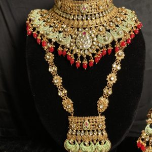 Complete your bridal look with our mesmerizing Indian choker set, featuring a choker necklace, mala, matha patti, jhumkas, hath panja, and nath/nose ring. Each piece is embellished with kundan stones and pearls for a touch of regal elegance.