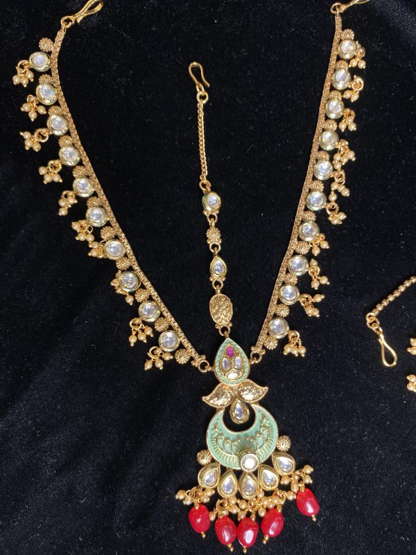 Complete your bridal look with our mesmerizing Indian choker set, featuring a choker necklace, mala, matha patti, jhumkas, hath panja, and nath/nose ring. Each piece is embellished with kundan stones and pearls for a touch of regal elegance.