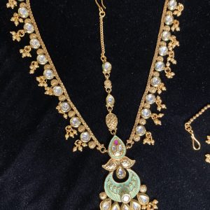 Complete your bridal look with our mesmerizing Indian choker set, featuring a choker necklace, mala, matha patti, jhumkas, hath panja, and nath/nose ring. Each piece is embellished with kundan stones and pearls for a touch of regal elegance.