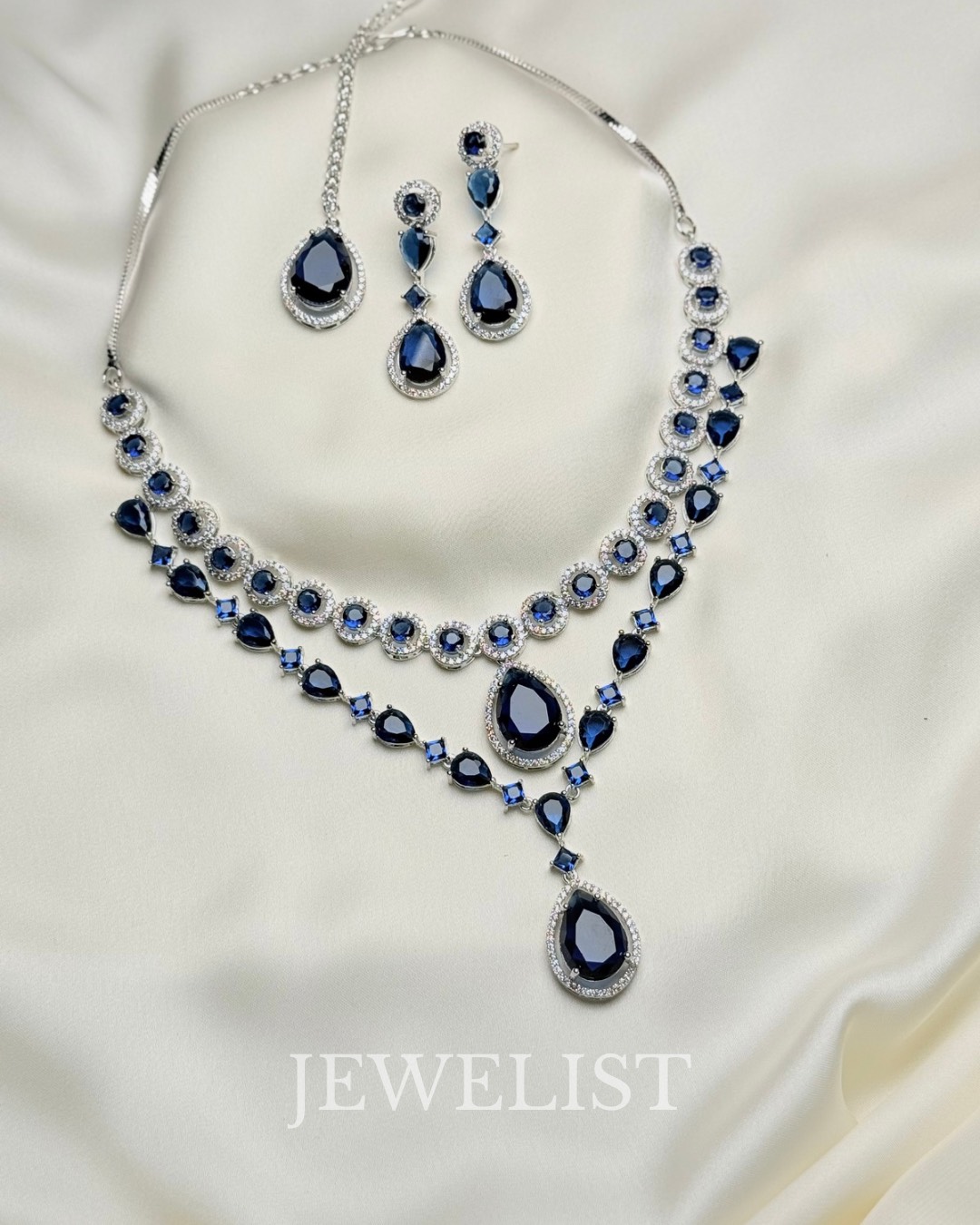 Twilight Brilliance Set by Jewelist.pk – two-layer sapphire blue necklace with teardrop gemstones and matching earrings, silver rhodium finish, Pakistani jewellery.