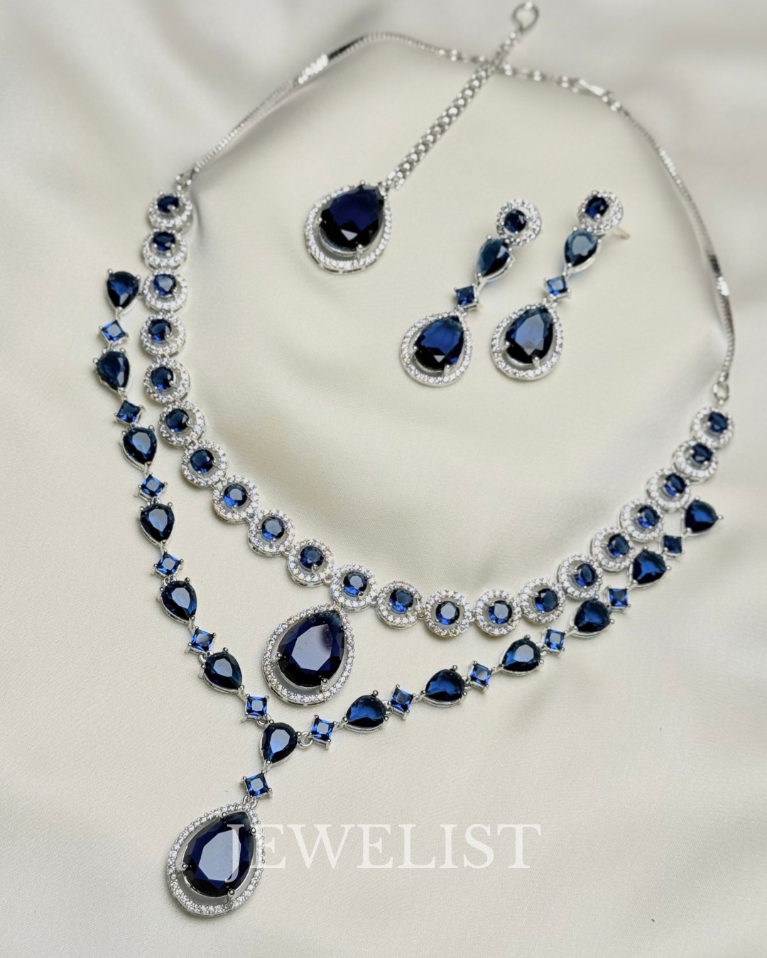 Twilight Brilliance Set by Jewelist.pk – two-layer sapphire blue necklace with teardrop gemstones and matching earrings, silver rhodium finish, Pakistani jewellery.