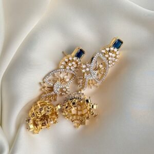 Crystal Breeze Jhumkas arranged on ivory fabric showing gold-tone openwork, dark blue-looking top stones and dome details