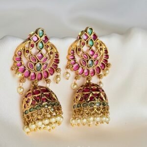 Gulaal Jhumkis front view showing matching pink and green gold-tone jhumka earrings with floral openwork and pearl-like fringe.