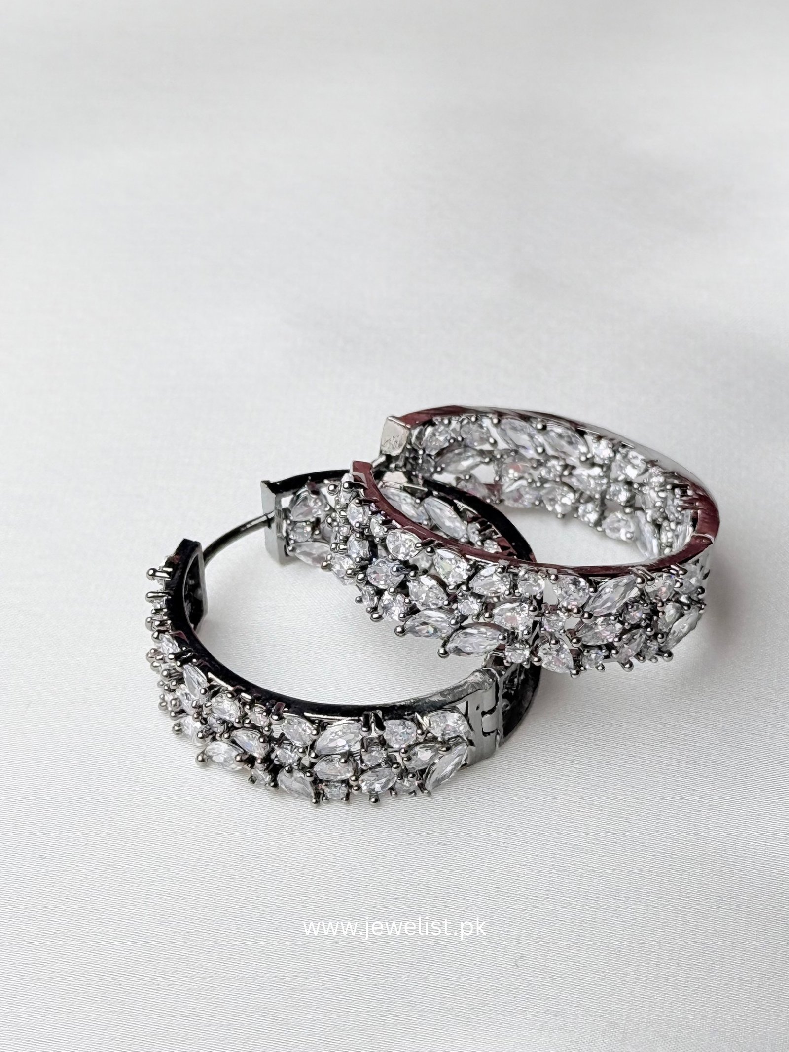Crystal Bloom Hoops oxidized silver-tone statement earrings with floral-inspired clear sparkling accents in overlapping close-up view